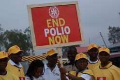 Volunteers hold an End Polio Now banner